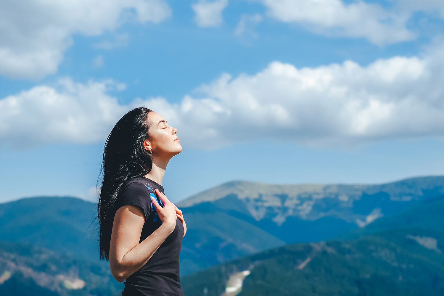 Long hair girl on the top of the mountain enjoying fresh air